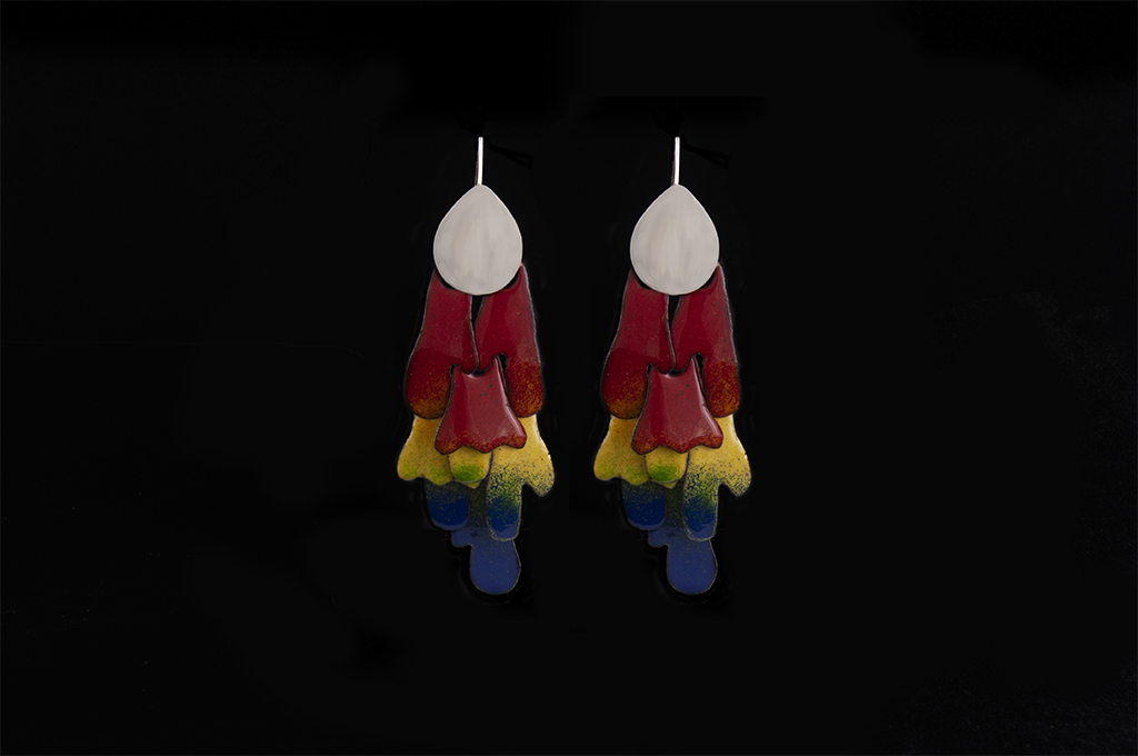 Image of enamel earrings. The top features a silver teardrop shape. Hanging from the teardrop shape are various organic shapes. The shapes have a color gradient going from: red to orange to yellow to green to blue. It mimics parrot wings.